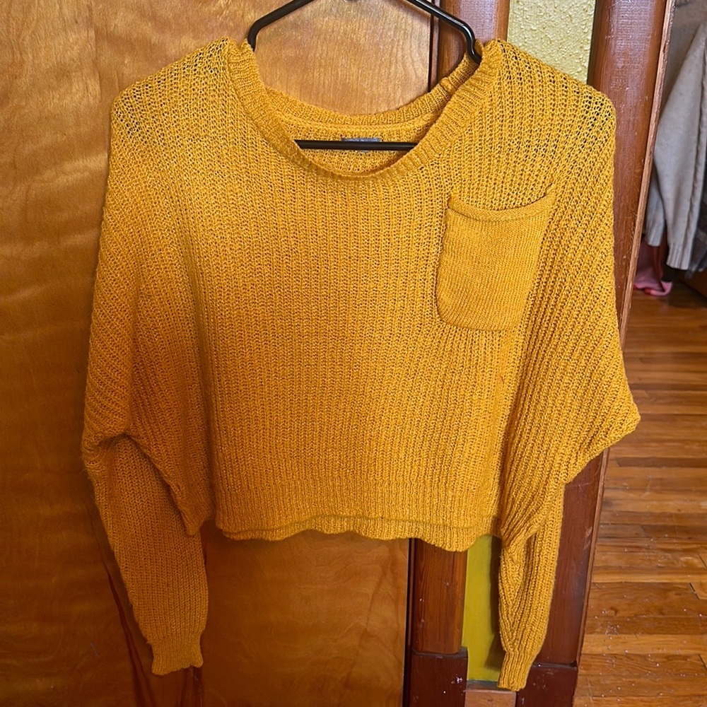 A mustard yellow cropped knitted sweater